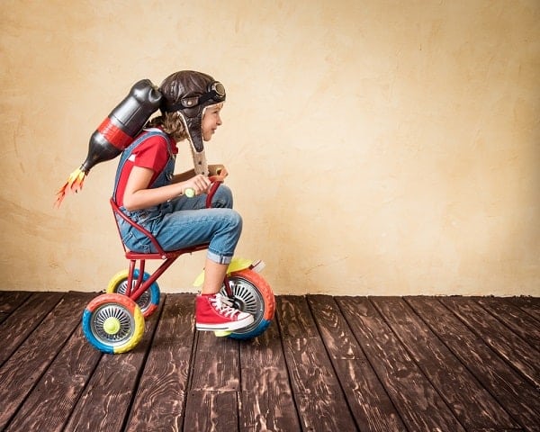 儿童用喷气背包骑自行车。孩子在家里玩。成功，领导者和获奖者的概念